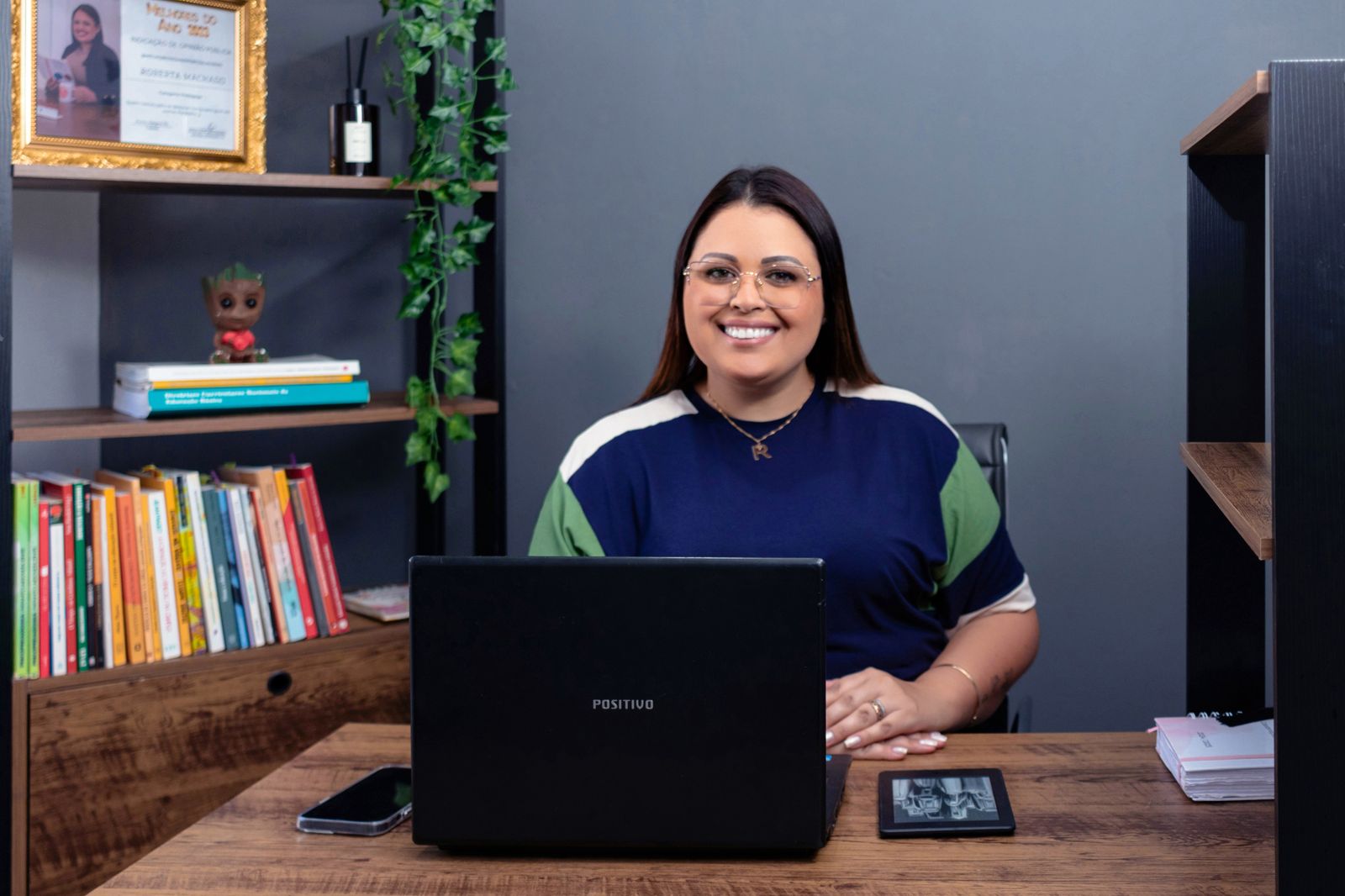 Roberta Machado em seu espaço de trabalho, ao lado de livros e materiais de Educação Infantil